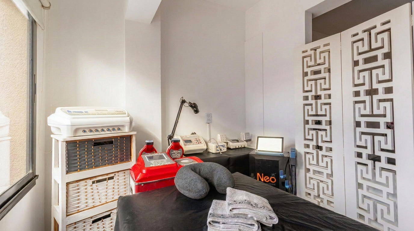 Sala de tratamientos con camilla preparada y aparatología: Body Up, presoterapia y equipo Neo.